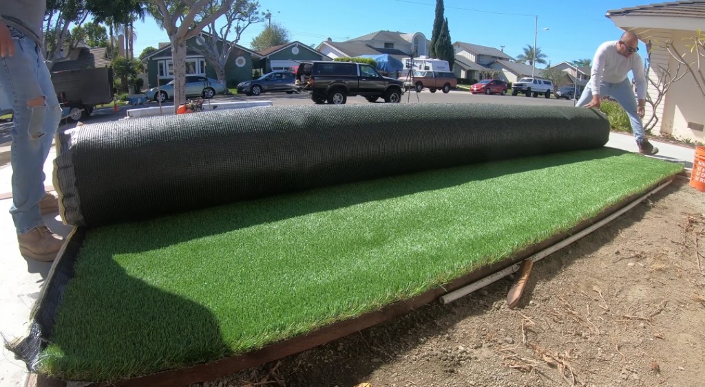 Professional crew installing artificial grass for mud-free lawn
